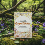 Livre coloré 5 Minutes de Gratitude de Christie Vanbremeersch posé sur une souche en forêt, couverture blanche tachetée de motifs joyeux jaunes et rouges.