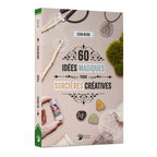 La couverture du livre "60 idées magiques pour sorcières créatives" de Lexa Olick, illustrée de divers objets artisanaux et ésotériques comme des runes, une fiole d'herbes et un pendentif, publiée aux Éditions Danaé.
