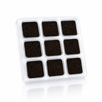Briques d'encens Aromafume, blister en plastique transparent contenant neuf carrés d'encens de couleur brun foncé disposés en grille sur fond blanc.