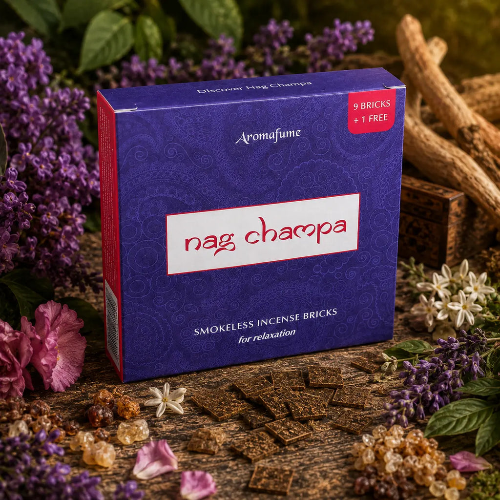 Briques d'encens Nag Champa Aromafume, boîte violette aux motifs paisley présentée au milieu de fleurs mauves, résine et carrés d'encens.
