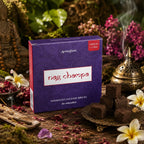 Boîte violette d'encens Aromafume Nag Champa entourée de fleurs tropicales et de pétales de rose, avec des briques d'encens carrées sur une coupelle en cuivre.