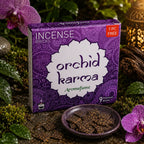 Boîte violette d'encens Aromafume Orchid Karma entourée d'orchidées roses et de mousse humide, avec des briques d'encens fines dans une coupelle en céramique.