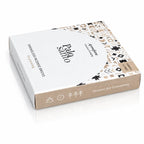 Briques d'encens Palo Santo Aromafume, boîte rectangulaire blanche et beige avec motifs géométriques ethniques noirs et dorés, et tranche couleur kraft illustrée de symboles.