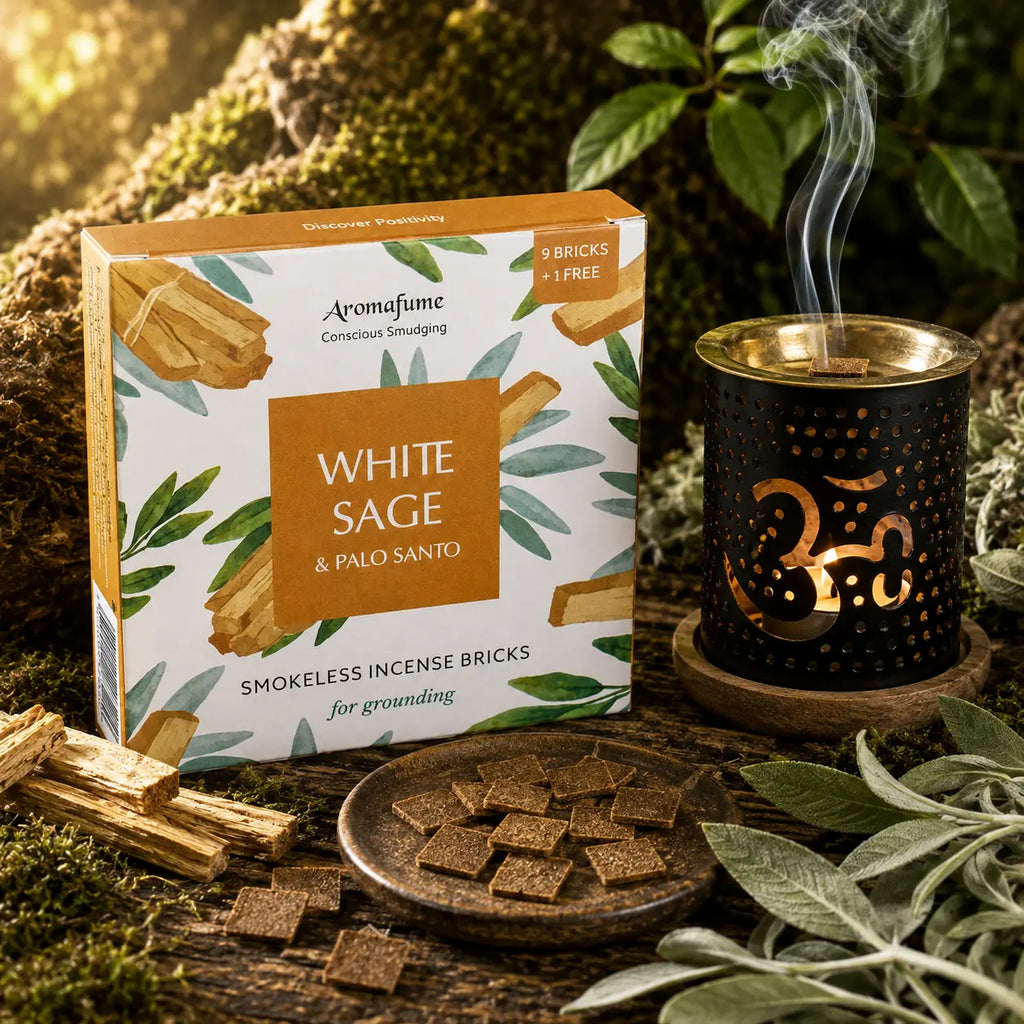 Boîte d'encens Aromafume White Sage & Palo Santo entourée de feuilles de sauge et de morceaux de Palo Santo, avec un brûleur d'encens noir au symbole Om.