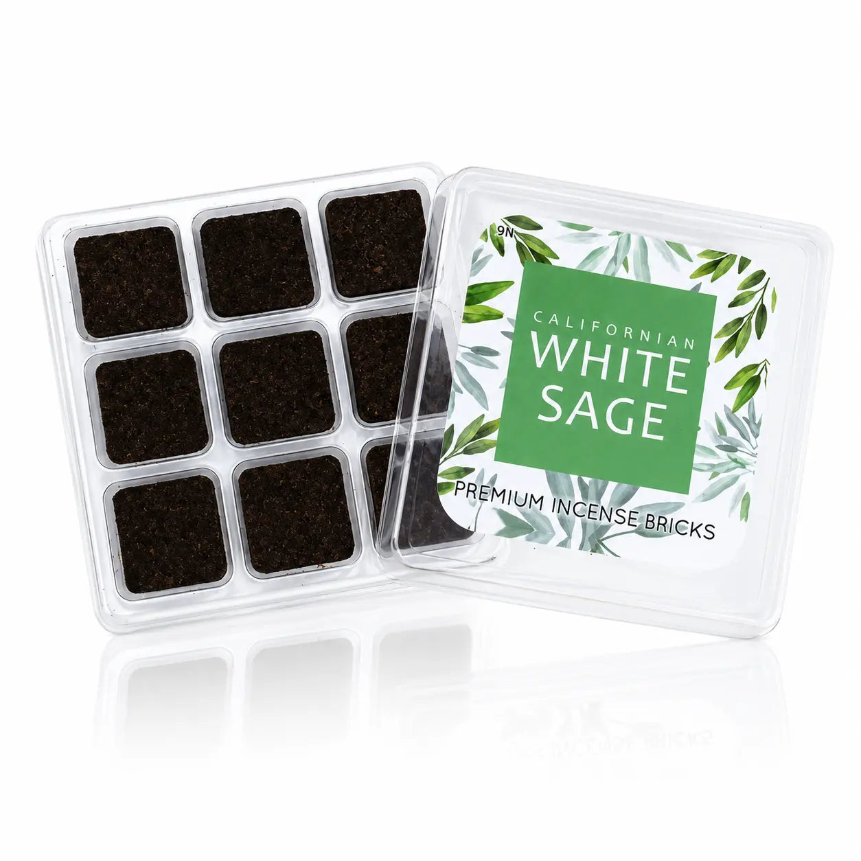 Briques d'encens sauge blanche Aromafume, boîte transparente ouverte révélant neuf carrés d'encens sombres et une étiquette verte illustrée de feuillage.