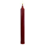 Bougie cylindrique rouge bordeaux allumée, à corps lisse et long, isolée sur fond blanc.
