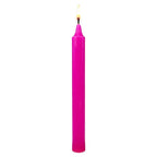 Bougie droite rose vif allumée, présentée seule sur fond blanc, bougie ésotérique teintée dans la masse.