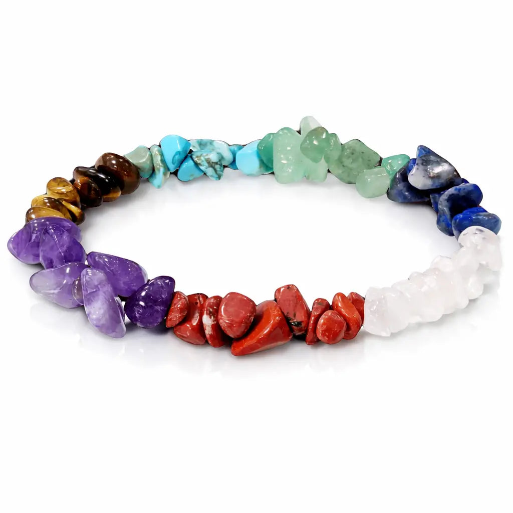 Un bracelet baroque en pierres naturelles des 7 chakras, composé de divers éclats polis (améthyste, lapis-lazuli, aventurine, etc.) représentant les couleurs énergétiques, présenté sur un fond blanc avec un léger reflet.