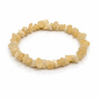 Un bracelet baroque en pierres naturelles d'aragonite, composé de petits éclats polis aux teintes jaune pâle et crème montés sur un fil élastique, présenté sur un fond blanc.