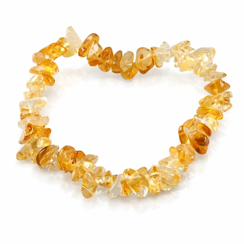 Un bracelet baroque en pierres naturelles de citrine, composé de petits éclats polis aux teintes jaune miel et translucides montés sur un fil élastique, présenté sur un fond blanc.
