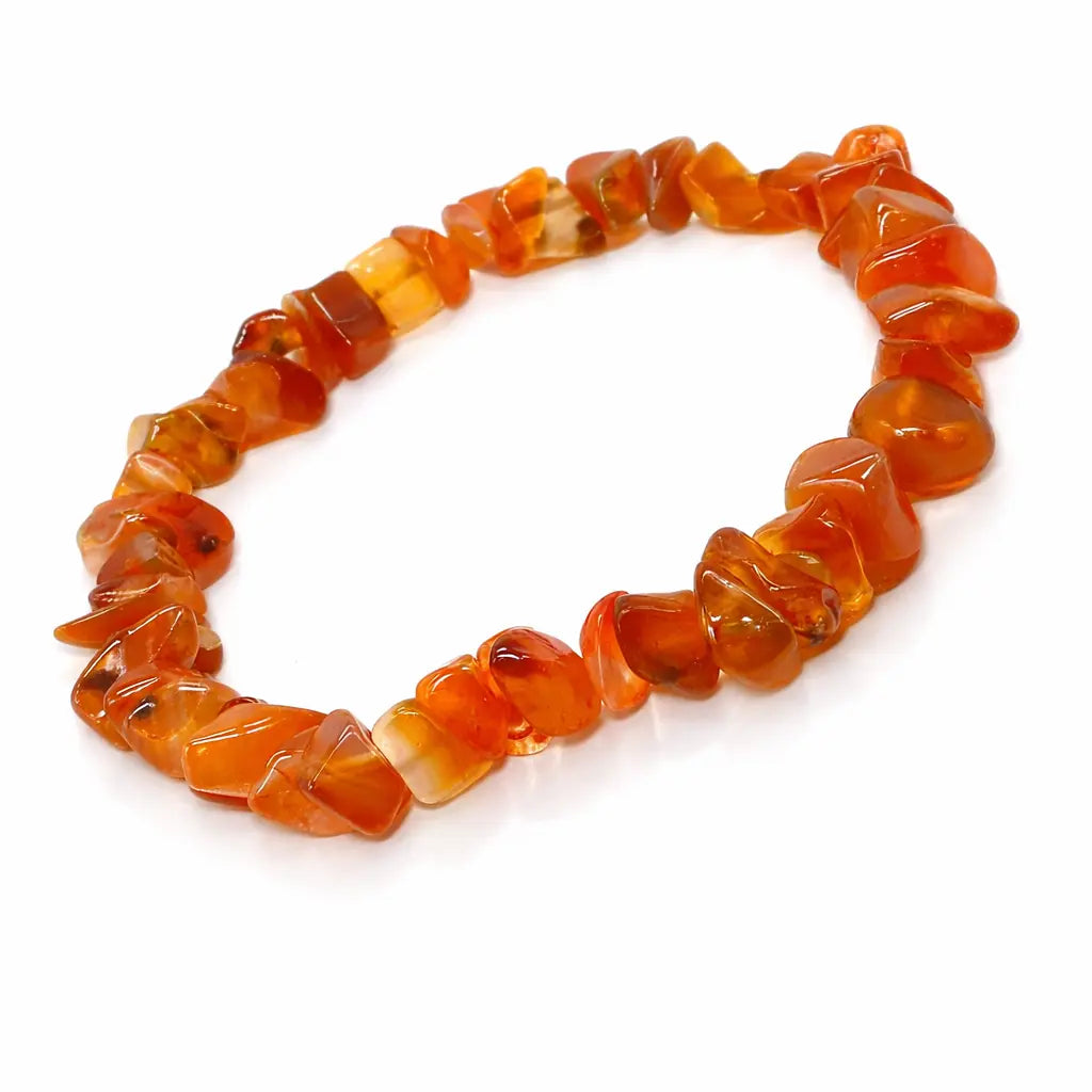 Un bracelet baroque en pierres naturelles de cornaline, composé de petits éclats polis aux nuances orange vif et translucides montés sur un fil élastique, présenté sur un fond blanc.