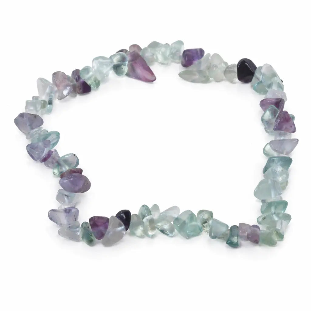 Un bracelet baroque en pierres naturelles de fluorite, composé de petits éclats polis aux nuances variées de violet, vert et translucide montés sur un fil élastique, présenté sur un fond blanc.