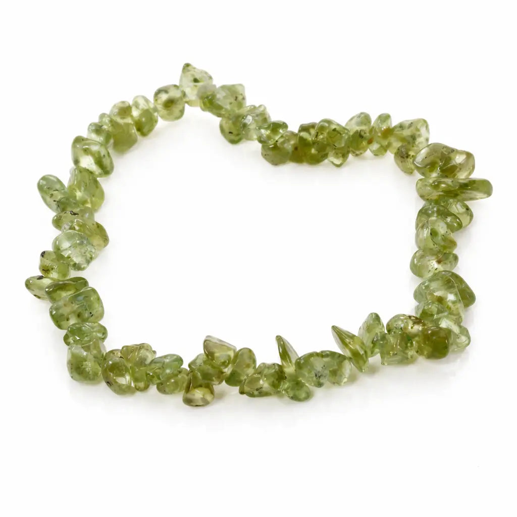 Bracelet en péridot aux éclats vert olive translucides, disposé en cercle sur un fond blanc avec reflet.