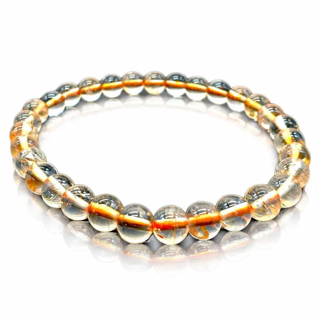 Bracelet élastique en perles rondes translucides jaune pâle, alignées en cercle sur fond clair
