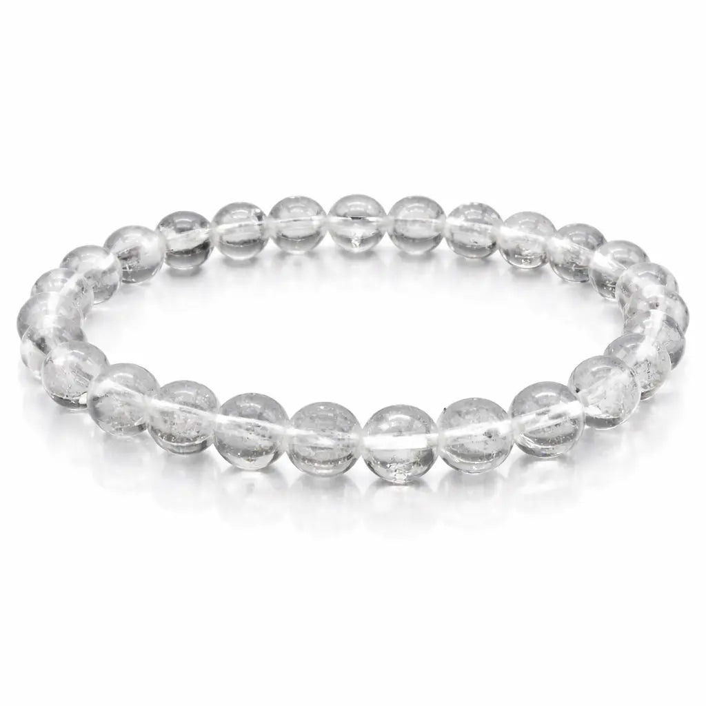 Bracelet élastique en perles rondes transparentes, aspect cristallin, disposé en cercle sur fond clair