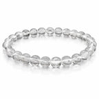 Bracelet élastique en perles rondes transparentes, aspect cristallin, disposé en cercle sur fond clair