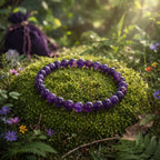 Bracelet de perles rondes en améthyste d'un violet sombre et profond, poli et scintillant sur un dôme de mousse forestière baigné d'une lumière mystique.