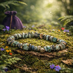Bracelet composé d'éclats baroques de turquoise africaine aux nuances bleu-vert terreuses et marbrures brunes, reposant sur une écorce ancienne dans un sous-bois mystique.