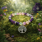 Bracelet de perles rondes en fluorite multicolore et améthyste violette avec une breloque Arbre de Vie en argent, posé sur de la mousse en forêt.