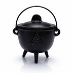Petit chaudron en fonte noire avec un symbole Triquetra gravé, couvercle et anse, sur un fond blanc.