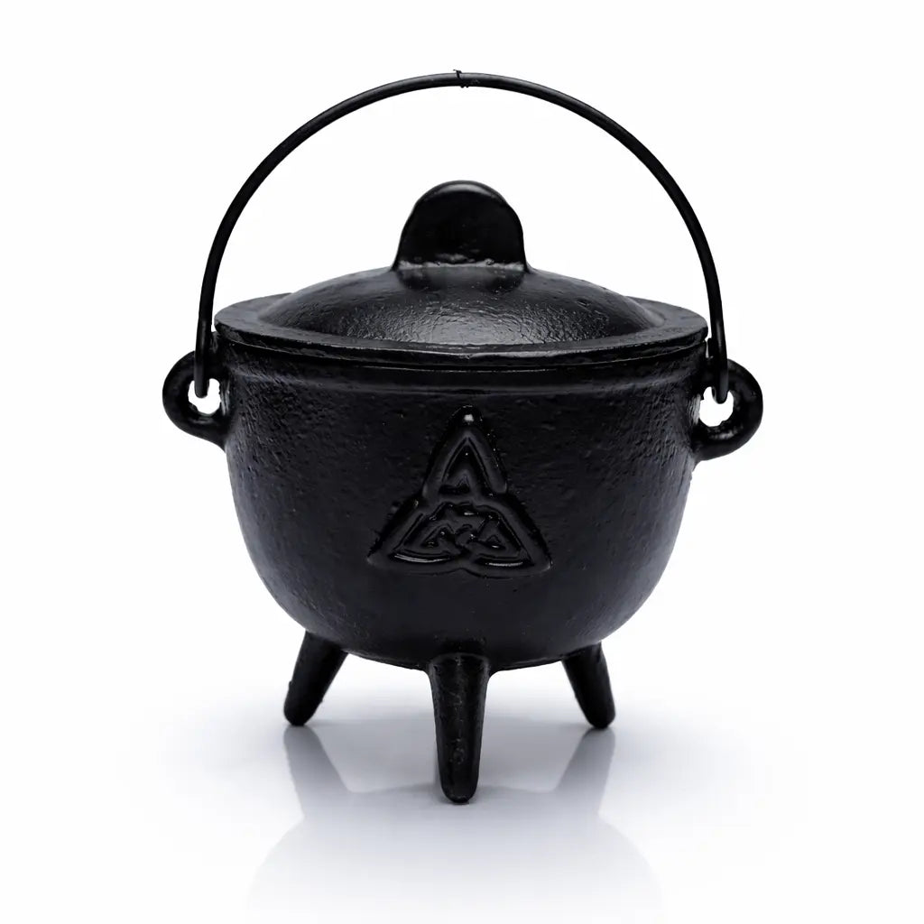 Petit chaudron en fonte noire avec un symbole Triquetra gravé, couvercle et anse, sur un fond blanc.
