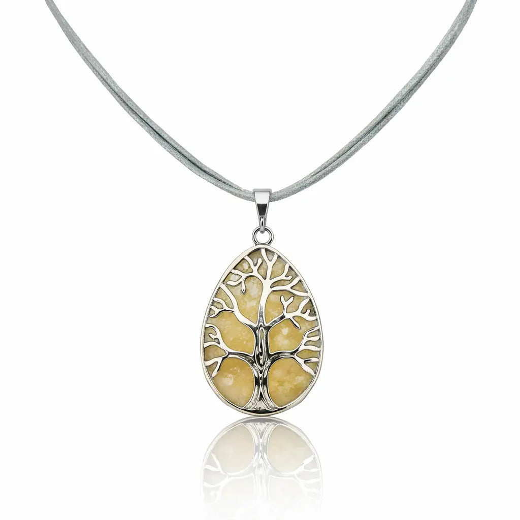 Pendentif goutte en jade jaune avec un collier arbre de vie argenté sur un cordon gris clair.