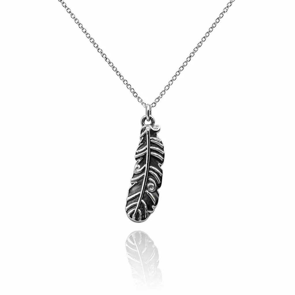 Pendentif plume d'ange en argent vieilli sur une fine chaîne à mailles, avec reflet sur fond blanc.