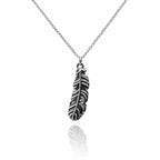 Pendentif plume d'ange en argent vieilli sur une fine chaîne à mailles, avec reflet sur fond blanc.