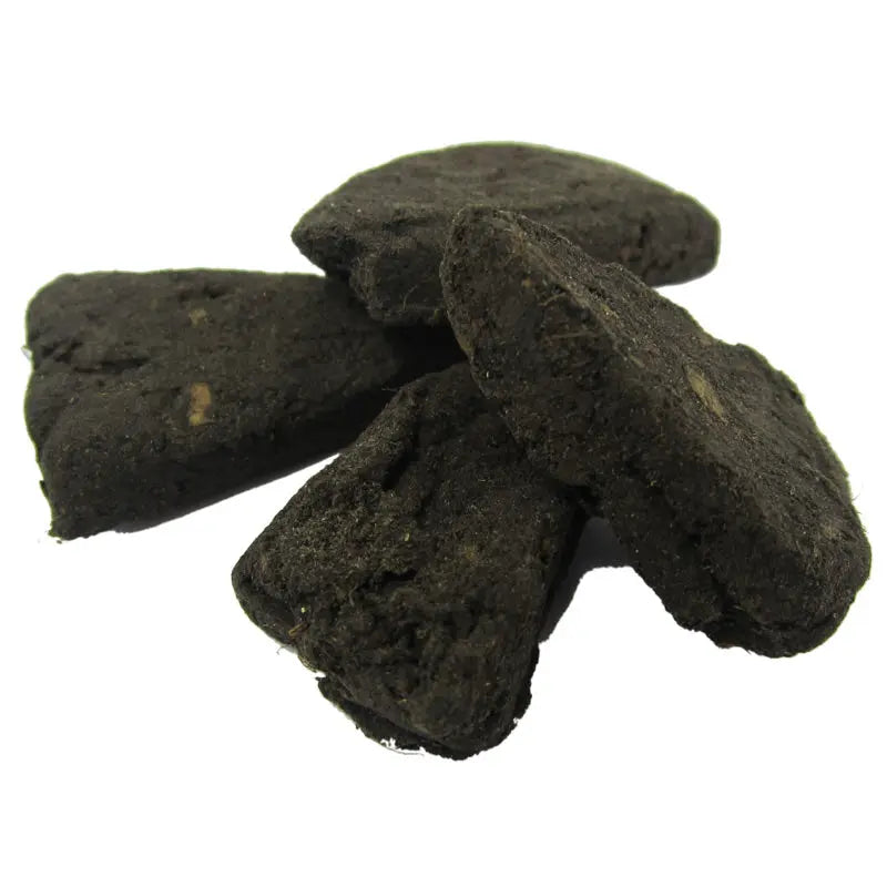 Morceaux d’encens noirs en gros plan sur fond blanc.
