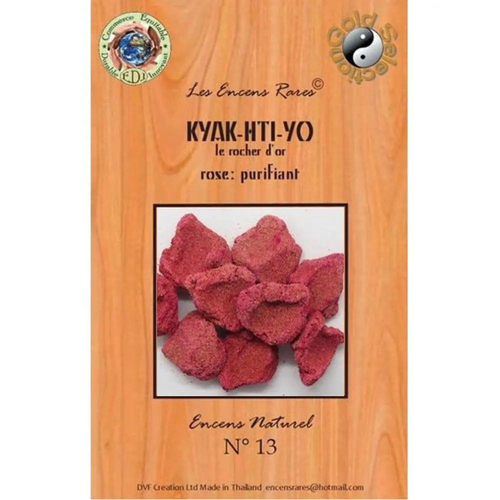 Encens Kyak-Hti-Yo sous forme de blocs rouges granuleux sur bois naturel avec encensoir fumant.