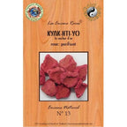 Encens Kyak-Hti-Yo sous forme de blocs rouges granuleux sur bois naturel avec encensoir fumant.