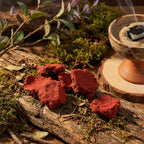 Encens Kyak-Hti-Yo sous forme de blocs rouges granuleux sur bois avec encensoir fumant.