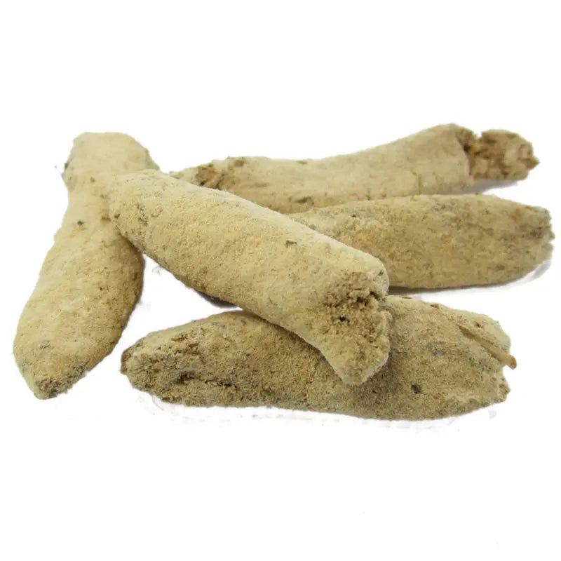 Bâtons d’encens beiges en gros plan sur fond blanc.