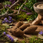 Cônes d'encens rares Terre de Siam bruts sur bois, entourés de fleurs violettes et encensoir en céramique.