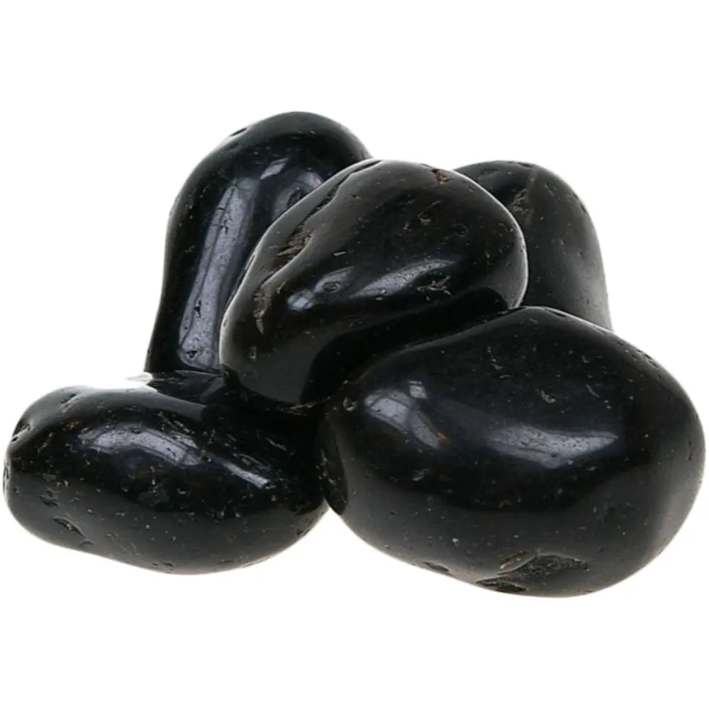 Un petit tas de pierres d'onyx noir roulées aux surfaces lisses et brillantes, présentant une couleur noire intense et profonde, regroupées sur un fond blanc uni.