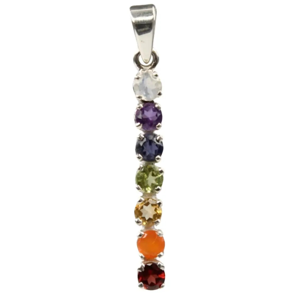 Un pendentif en argent composé de sept pierres naturelles taillées et alignées verticalement aux couleurs des chakras, surmonté d'une bélière, sur fond blanc.