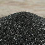 Gros plan sur du sable de lave noir contenu dans un encensoir en métal, idéal pour la fumigation d'encens.