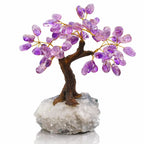Une autre vue d'un arbre du bonheur mettant en avant son tronc brun sinueux et ses éclats d'améthyste, fixé sur une base en cristal de roche naturel, présenté sur fond blanc.