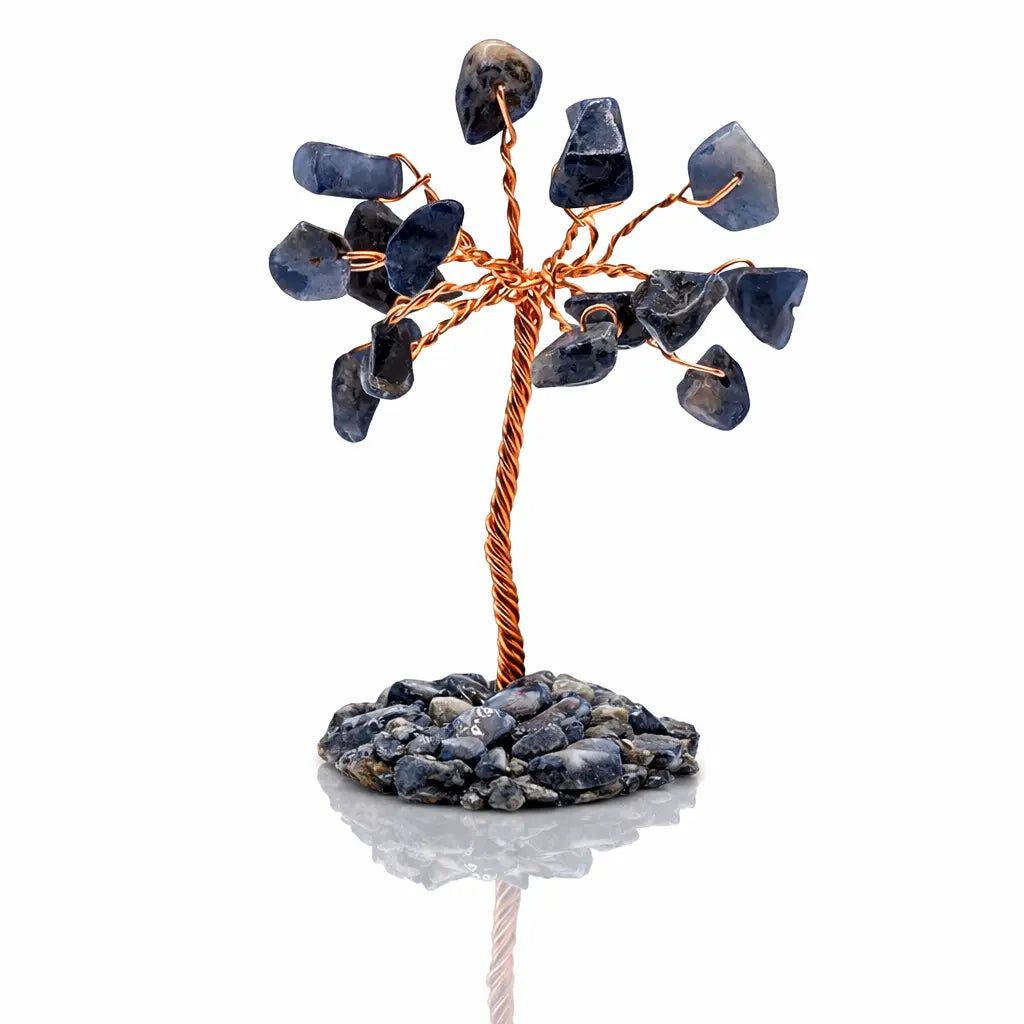Un arbre du bonheur décoratif composé d'un tronc en fil de cuivre torsadé et de feuilles en pierres de sodalite bleue, fixé sur un socle de petits éclats minéraux assortis, présenté sur fond blanc.