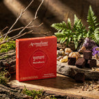 Boîte rouge et carrés compacts de Briques d'Encens Chakra 1 Racine Muladhara posés sur pierre naturelle pour rituel d'ancrage
