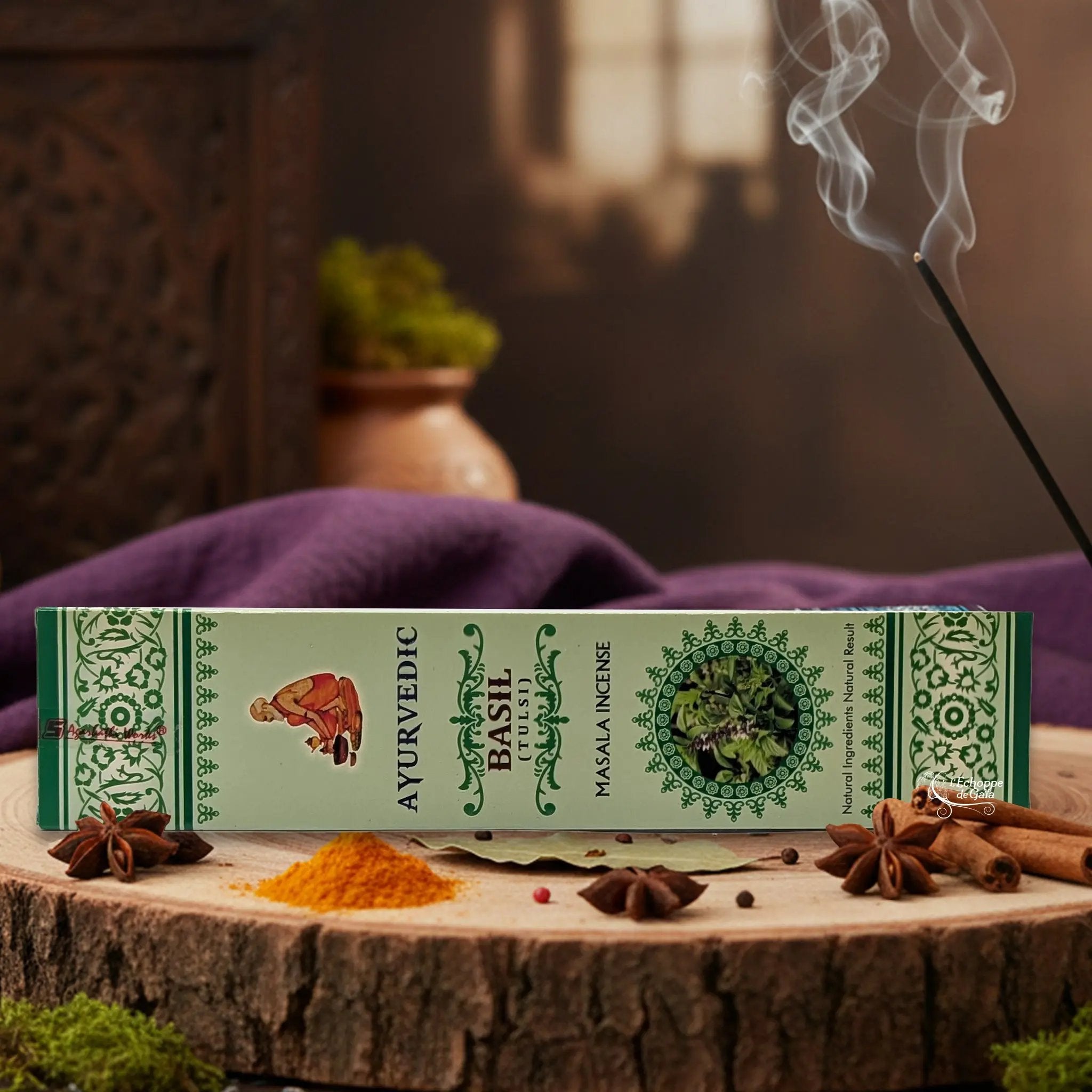 Boîte d'encens "Ayurvedic Basil Tulasi Masala" sur une rondelle de bois, avec épices et encens fumant.