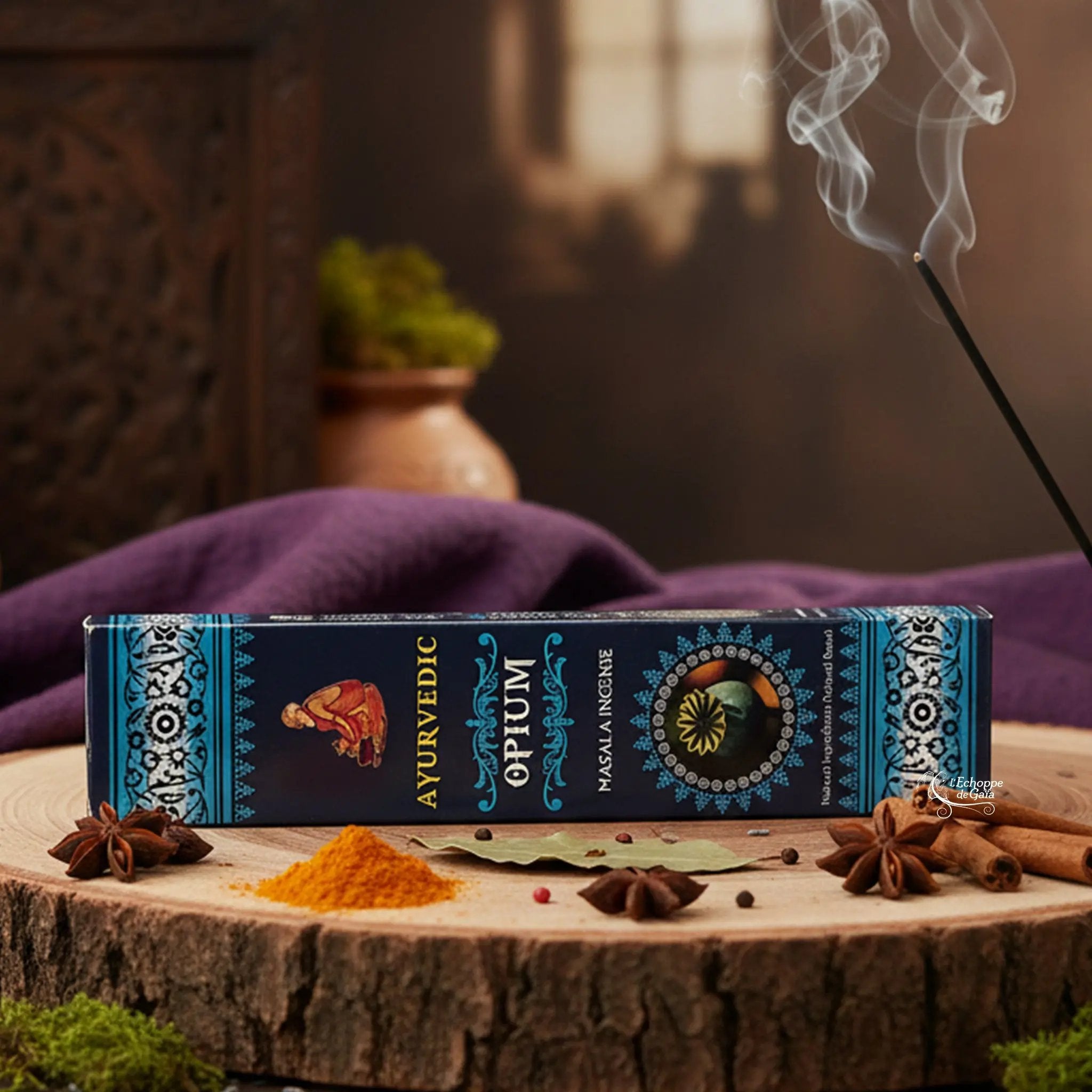 Boîte d'encens "Ayurvedic Opium Masala" sur une rondelle de bois, avec épices et encens fumant.