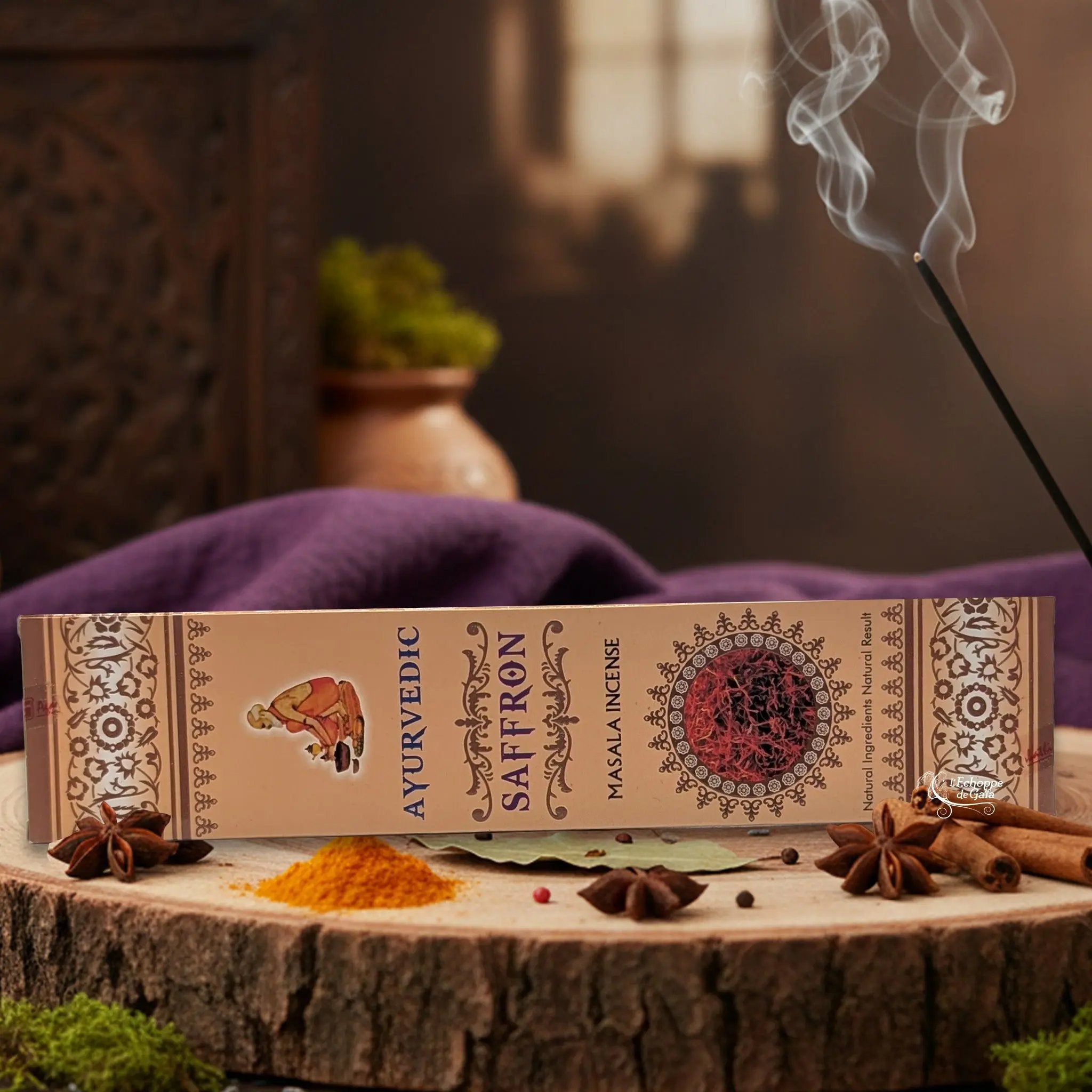 Boîte d'encens "Ayurvedic Saffron Masala" sur une rondelle de bois, avec épices et encens fumant.