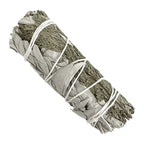 Bâton purificateur sauge blanche et cèdre pour fumigation, herbes vert gris ficelées de blanc sur fond blanc.