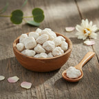 Encens benjoin blanc en grains dans une coupelle en bois avec petite cuillère sur table en bois.