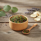 Grains d'encens de résine Bethléem, mélange de couleurs (vert émeraude, rouge, et noir), dans un petit bol en bois avec cuillère, sur une planche de bois rustique.