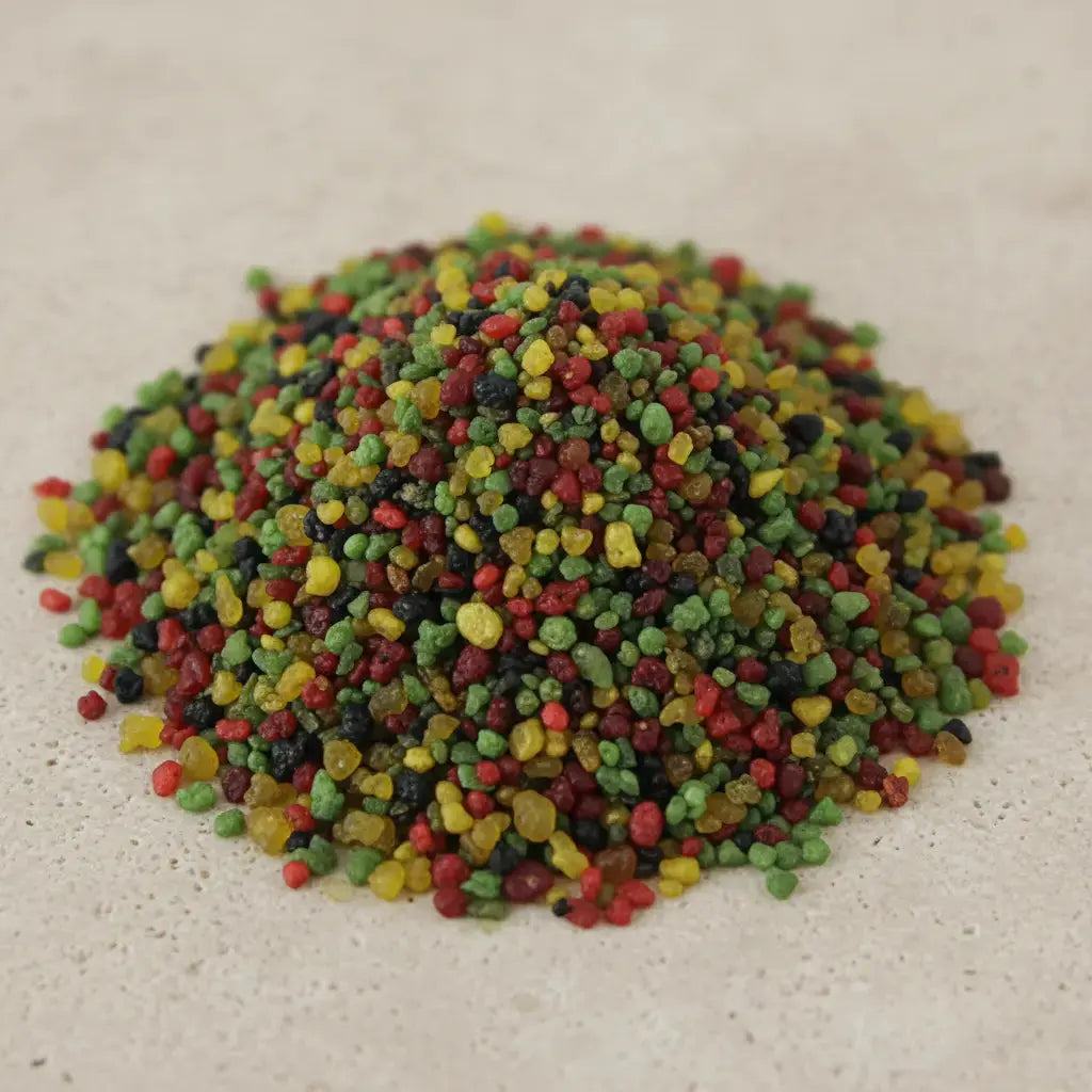 Gros plan sur un monticule de grains d'encens de résine Bethléem, montrant un mélange dense de couleurs vives (rouge, vert, jaune et noir).