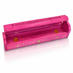 Boîte porte-encens en bois rose entrouverte, décorée de lunes, d'étoiles et d'un soleil dorés, révélant deux petites coupelles en laiton à l'intérieur, sur fond blanc.