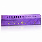 Boîte porte-encens en bois violet fermée, arborant des incrustations dorées de lunes, d'étoiles et d'un soleil, avec un couvercle finement ajouré de motifs losanges, sur fond blanc.