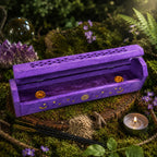 Boîte Porte Encens en Bois Manguier - Soleil & Lune Bleu Violet entrouverte sur un lit de mousse, dévoilant ses supports dorés intérieurs près de cônes et de bâtonnets.